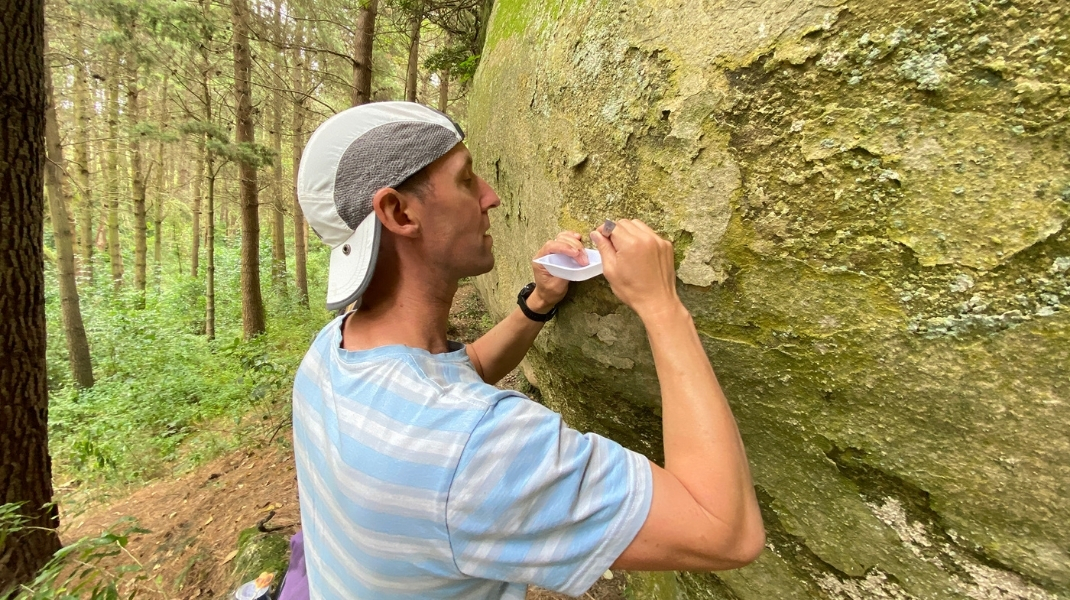 Dr Phil Novis collecting a sample at a rock art site. Image: John Hunt